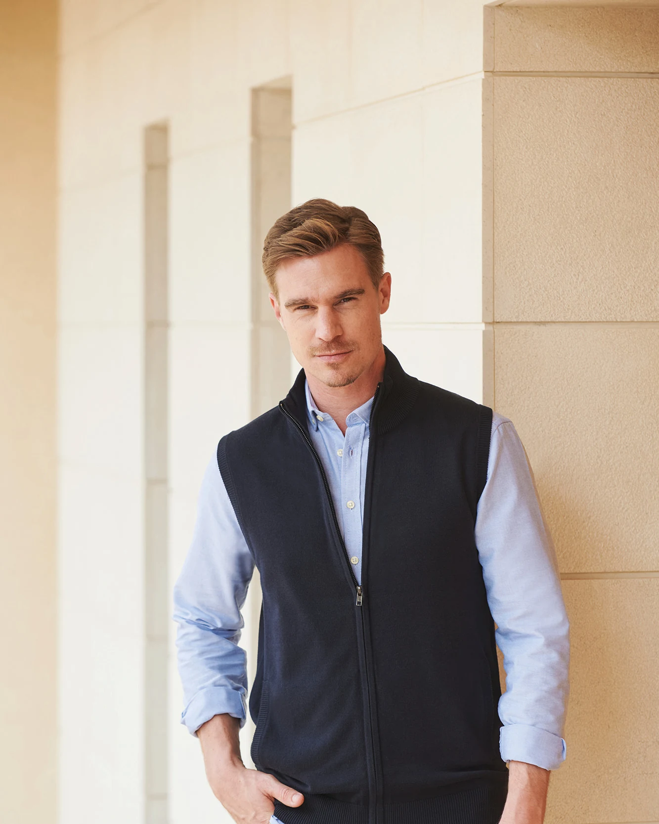 Henbury H711 gebreide herenbodywarmer met rits gedragen door een model